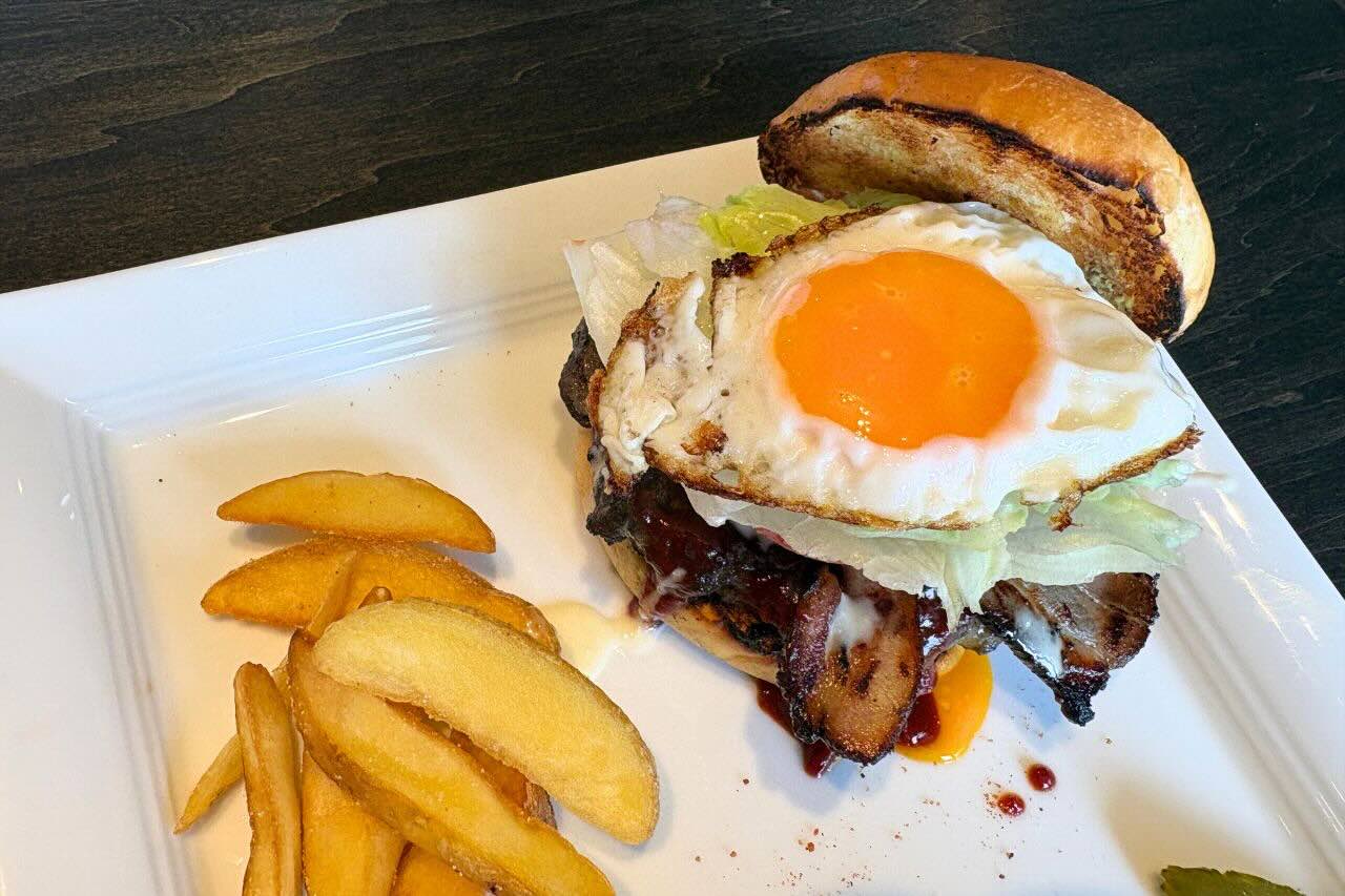 炭火かおるアメリカンダイナー「GRILL JOCKEY（グリル ジョッキー）」の薩摩黒豚100％の贅沢バーガーにかぶりつく（沖縄市）