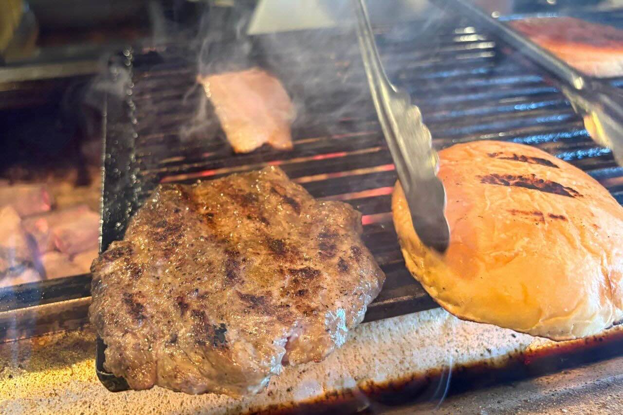 炭火かおるアメリカンダイナー「GRILL JOCKEY（グリル ジョッキー）」の薩摩黒豚100％の贅沢バーガーにかぶりつく（沖縄市）