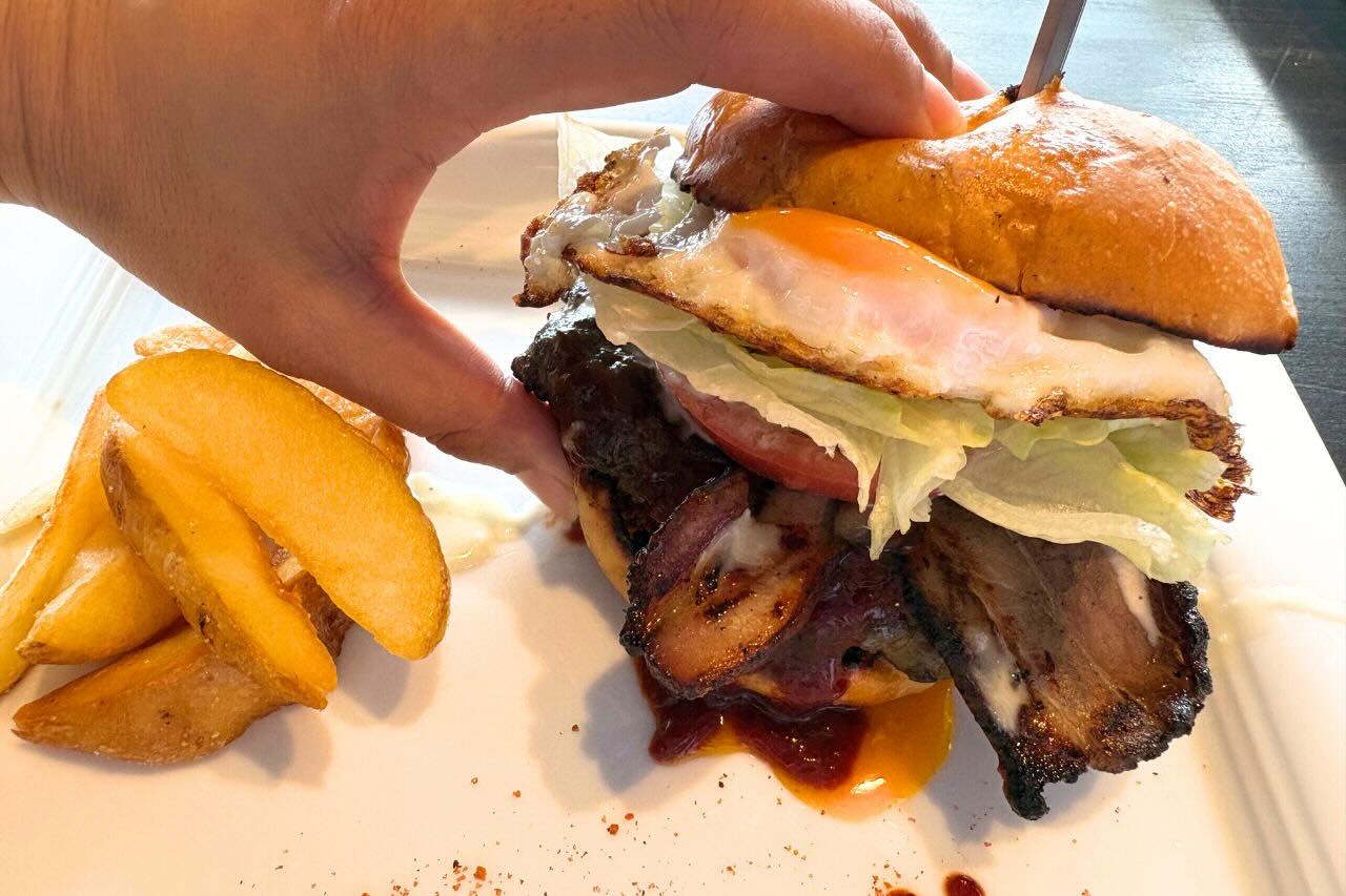 炭火かおるアメリカンダイナー「GRILL JOCKEY（グリル ジョッキー）」の薩摩黒豚100％の贅沢バーガーにかぶりつく（沖縄市）